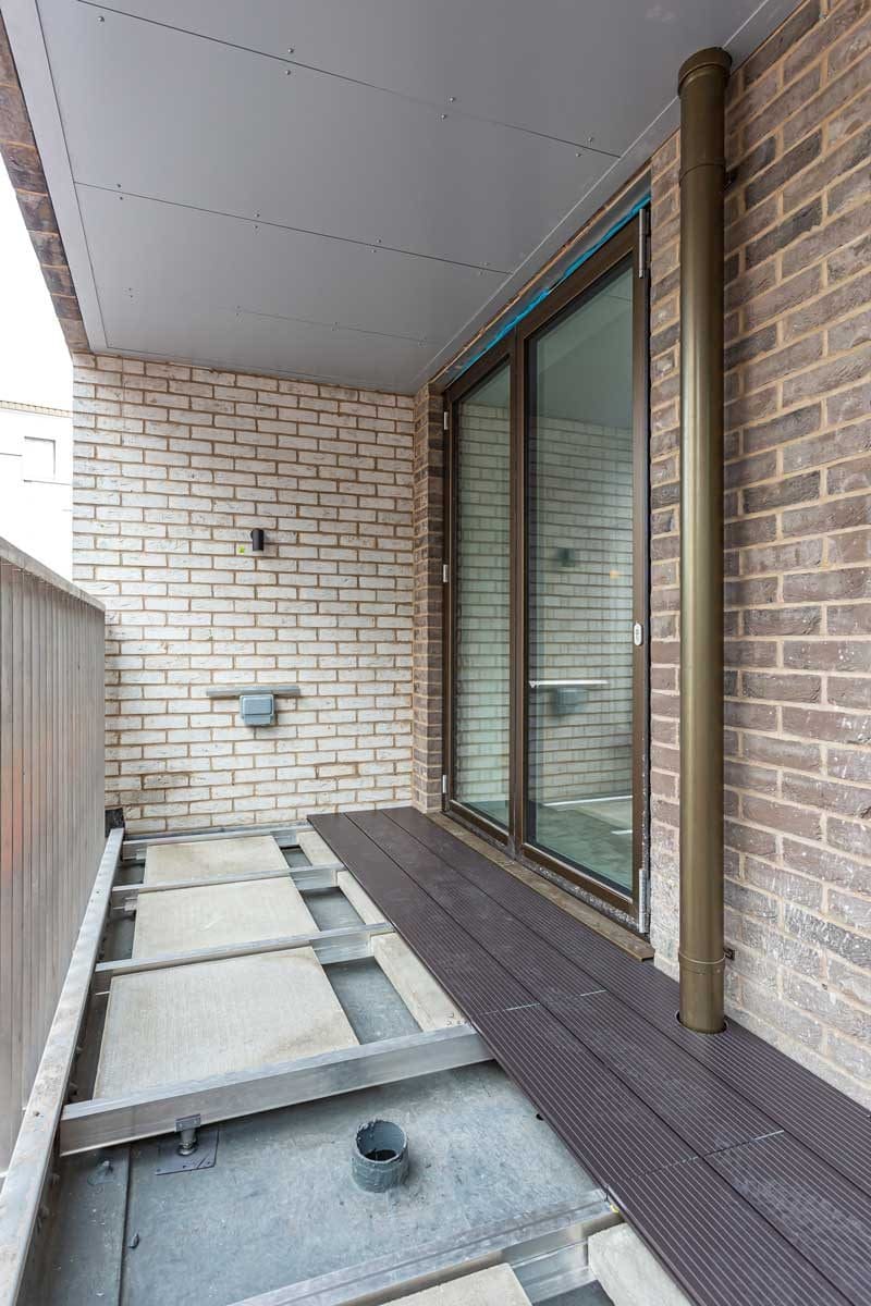 Decking in RAL 7016 provides contrast from the light brick and bronze detail.