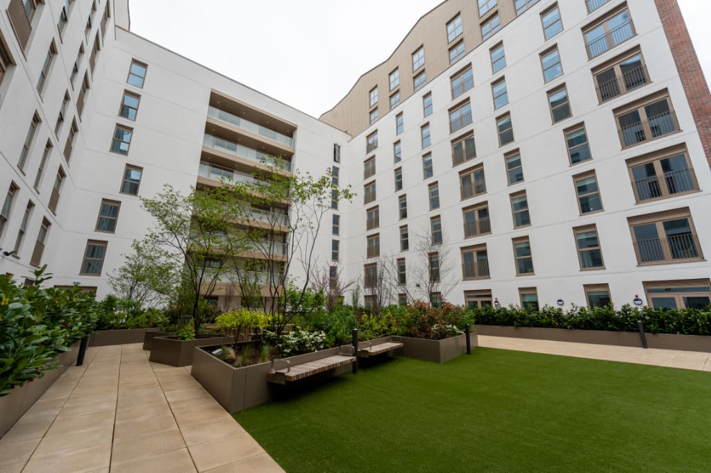 Planters with seating on artificial grass and paving