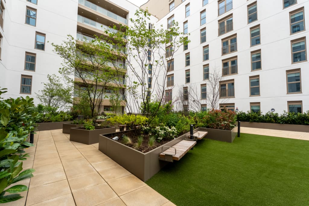 Planters with seating on artificial grass and paving