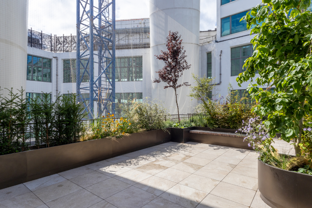 Paved roof terrace with planter and seating